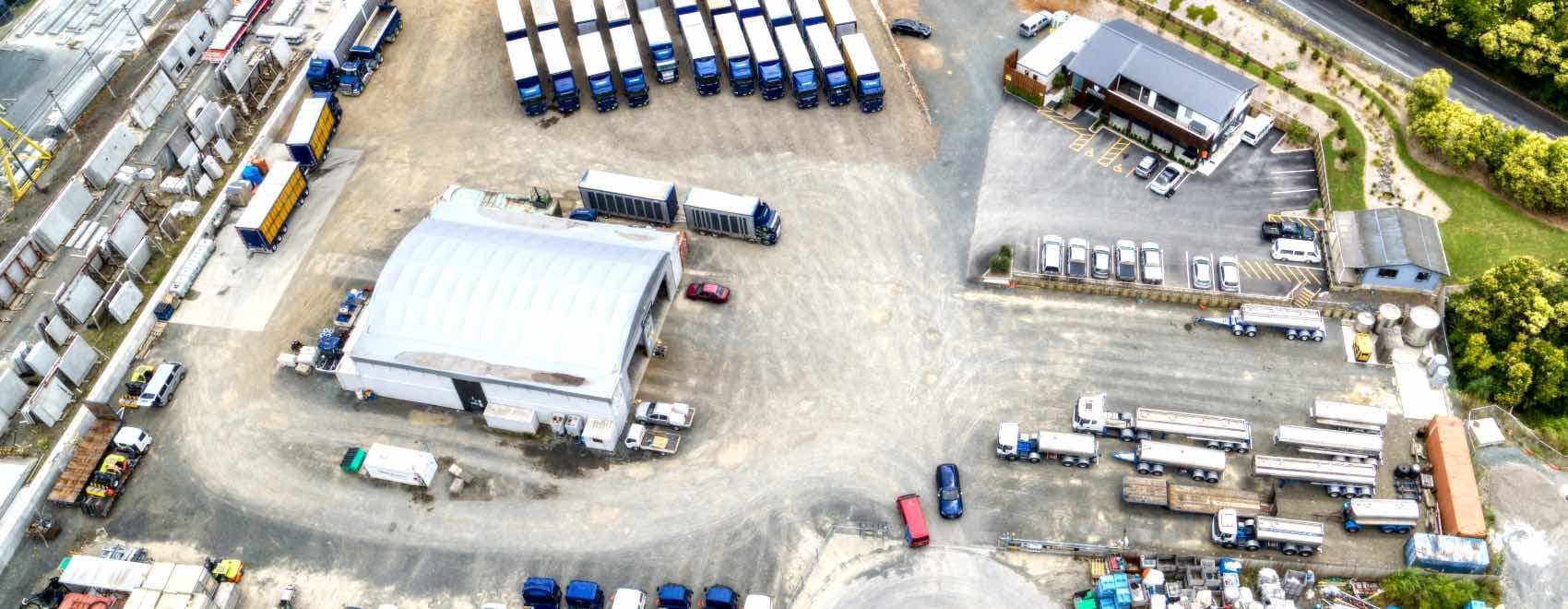 A birds eye view of a shipping yard with numerous semi trucks parked neatly.